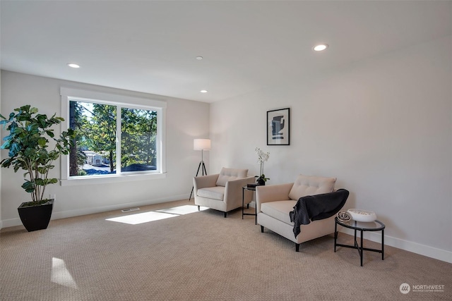 sitting room with recessed lighting, light carpet, and baseboards