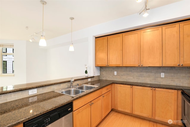 kitchen featuring light wood-type flooring, backsplash, dark stone countertops, decorative light fixtures, and sink