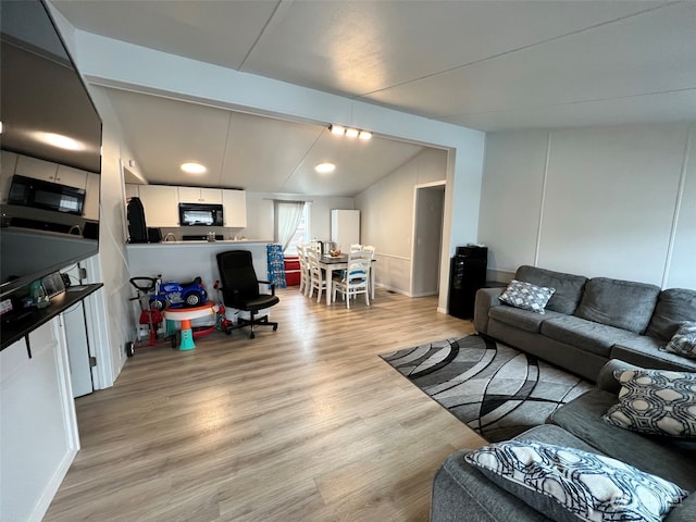 living room featuring light wood-type flooring and lofted ceiling