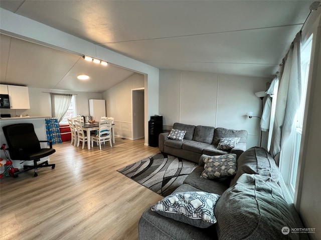 living area with vaulted ceiling and light wood finished floors