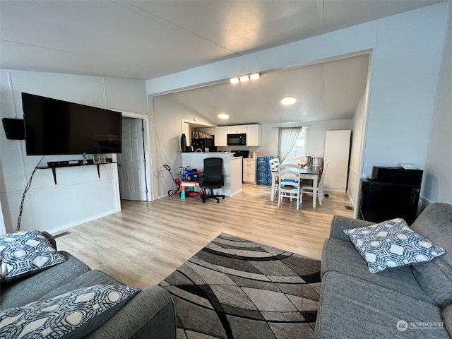 living room featuring light wood-type flooring and vaulted ceiling