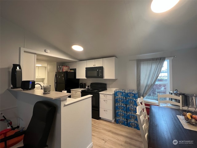 kitchen with black appliances, white cabinetry, a peninsula, light countertops, and lofted ceiling