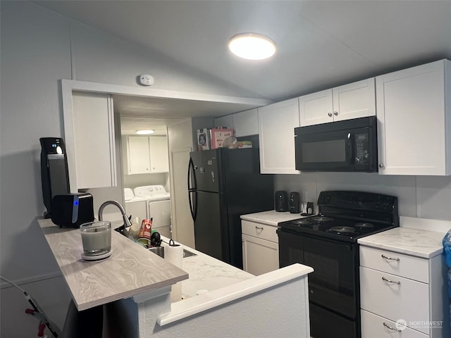 kitchen featuring black appliances, light stone counters, separate washer and dryer, white cabinetry, and a sink