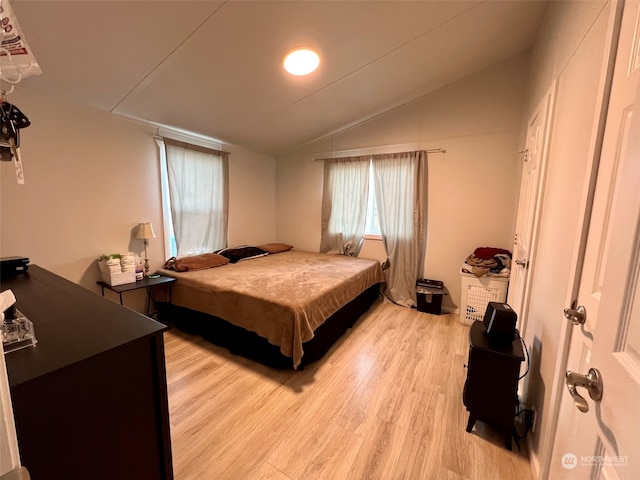 bedroom featuring vaulted ceiling and light wood-style floors