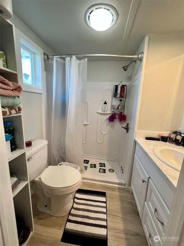 full bath featuring a stall shower, toilet, and wood finished floors