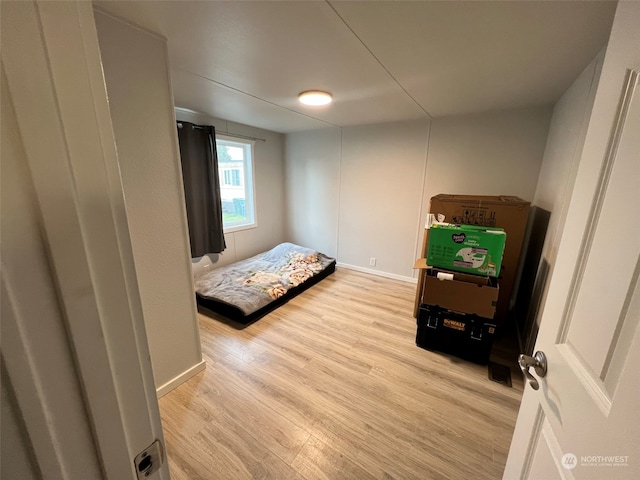 bedroom featuring light wood-style floors and baseboards