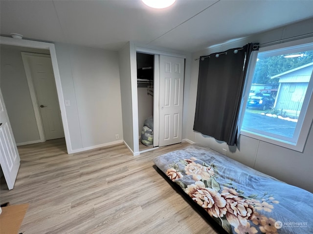 unfurnished bedroom with light wood finished floors, baseboards, and a closet