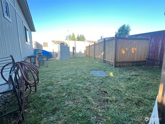 view of yard with a storage shed, an outdoor structure, and fence