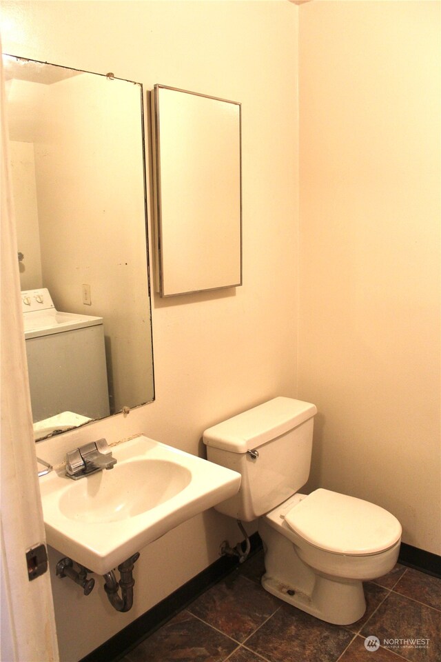 bathroom featuring sink, toilet, tile floors, and washer / dryer