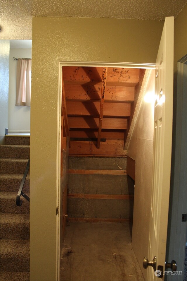 stairs with a textured ceiling