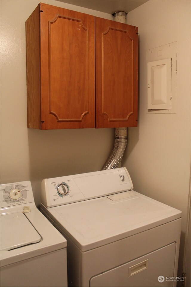 washroom with washing machine and clothes dryer and cabinets