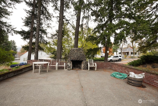 view of front facade featuring an outdoor stone fireplace and a patio