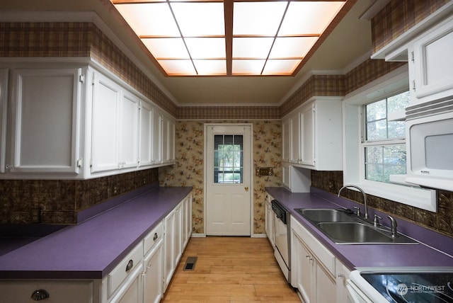 kitchen featuring white cabinetry, dishwashing machine, light hardwood / wood-style floors, sink, and stove