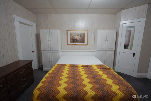 carpeted bedroom with a paneled ceiling and a closet