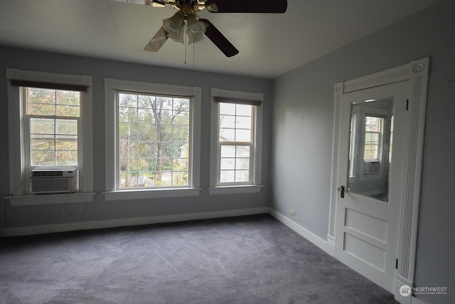 unfurnished room with ceiling fan, dark carpet, and a healthy amount of sunlight