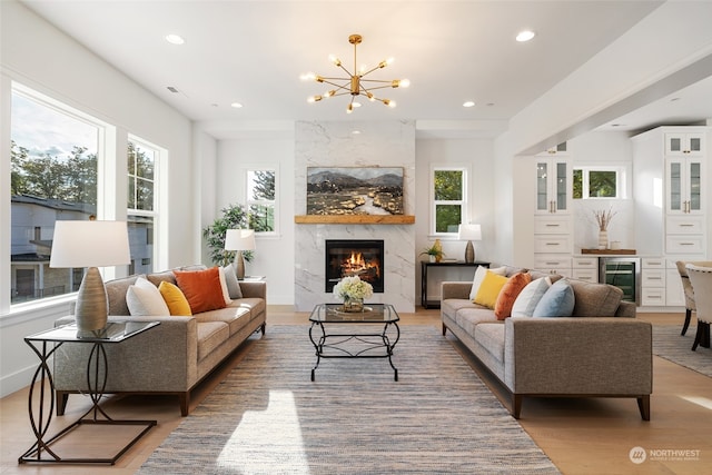 living room with wine cooler, a fireplace, recessed lighting, visible vents, and light wood-style floors