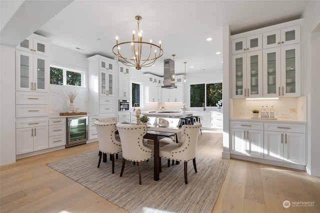 dining area with beverage cooler, recessed lighting, an inviting chandelier, and light wood-style floors