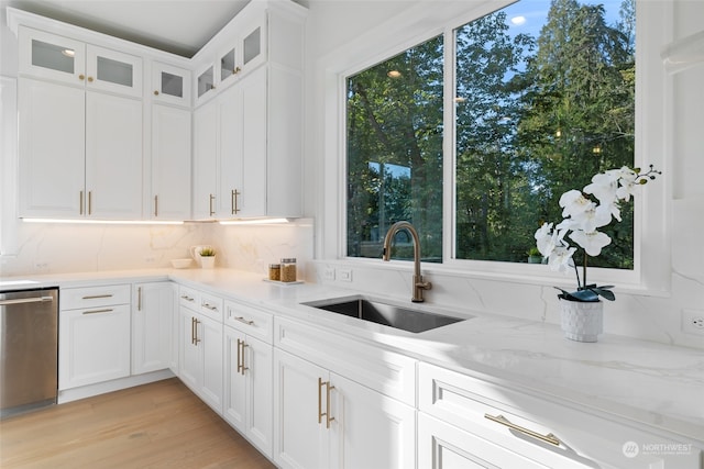 kitchen with white cabinets, light hardwood / wood-style floors, sink, and stainless steel dishwasher