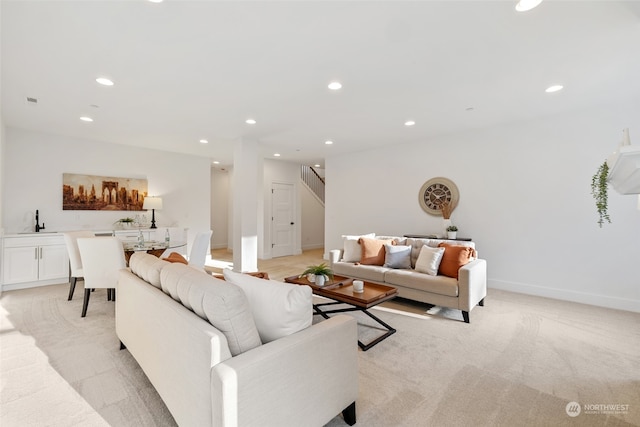 living room with light colored carpet and sink