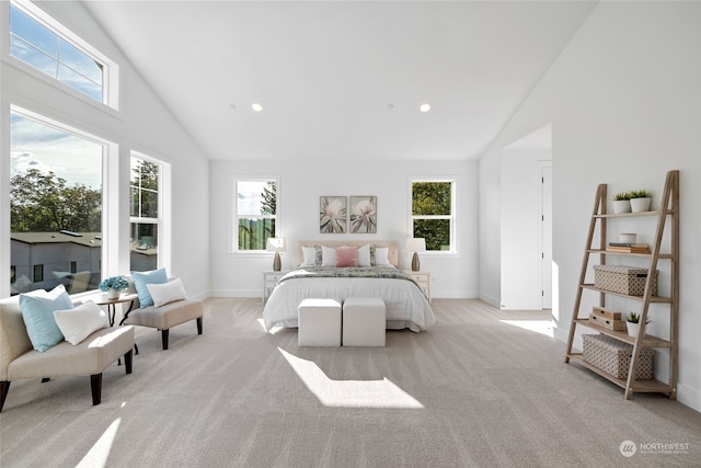 bedroom with high vaulted ceiling, light colored carpet, and multiple windows