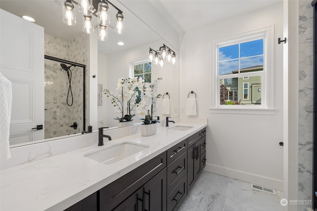 full bath featuring baseboards, visible vents, a sink, and a marble finish shower