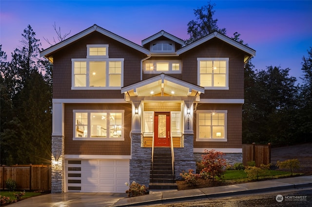 craftsman-style home with driveway, stone siding, a garage, and fence