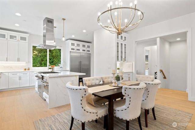 dining area featuring a chandelier, recessed lighting, and light wood-style flooring