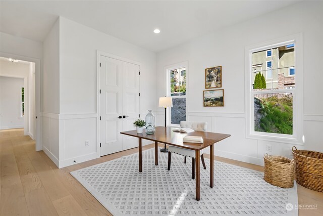 office area with light wood finished floors, wainscoting, a decorative wall, and recessed lighting