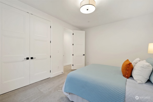 bedroom featuring a closet and light colored carpet