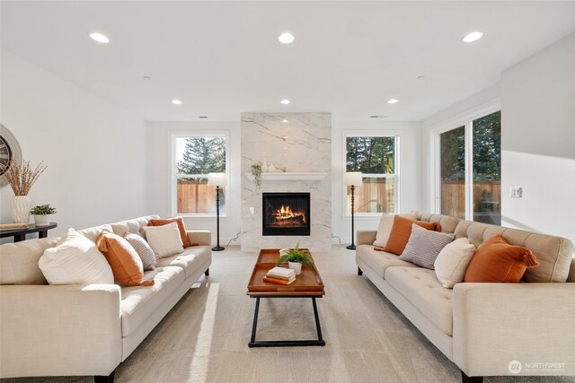 living room featuring light carpet, a high end fireplace, and recessed lighting