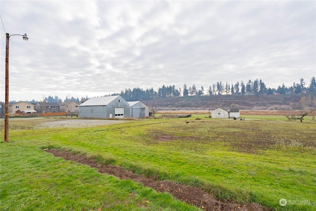 view of yard with an outdoor structure and a rural view