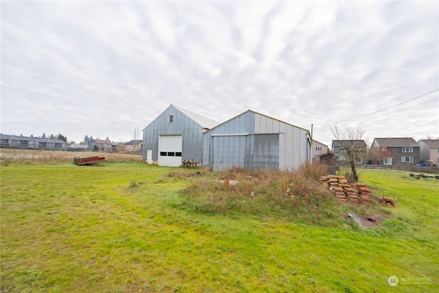 view of yard with a garage and an outbuilding