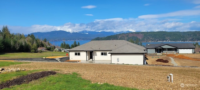 ranch-style home with a water and mountain view and a front lawn