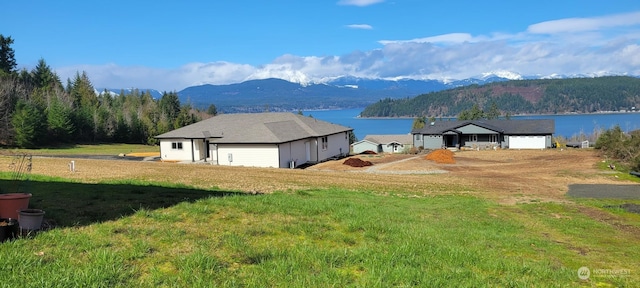 view of yard featuring a water and mountain view and a garage