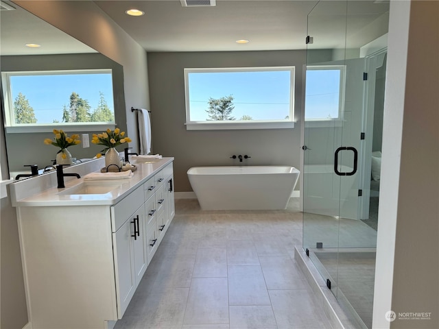 bathroom with tile patterned floors, vanity, and shower with separate bathtub