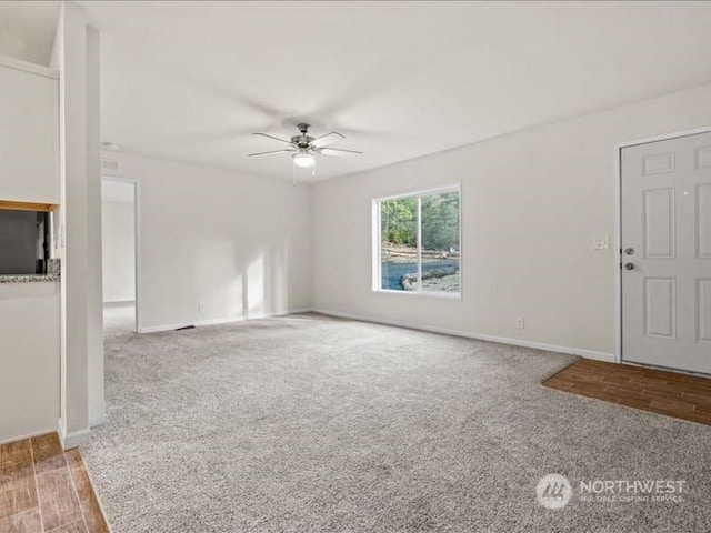 unfurnished living room with light colored carpet and ceiling fan