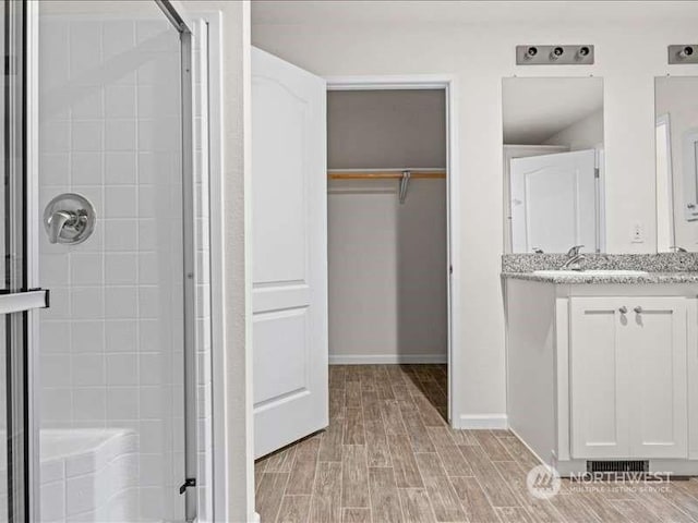 670 E Wilson Way, Grapeview, WA 98546 - full bathroom with a shower stall, a spacious closet, vanity, and wood finished floors