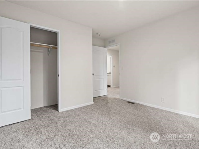 unfurnished bedroom featuring a closet and light colored carpet