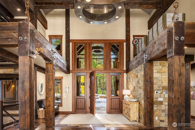 entryway featuring beam ceiling and a towering ceiling