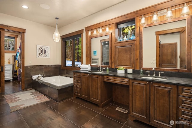 bathroom with tile patterned floors, double vanity, a garden tub, and a sink