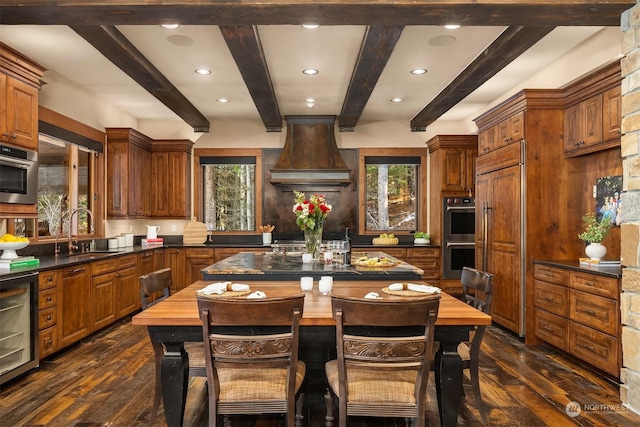 kitchen with a center island, premium range hood, dark wood finished floors, beverage cooler, and a sink