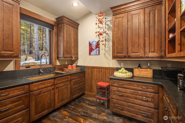 kitchen with a sink, dark wood-style flooring, brown cabinets, recessed lighting, and wainscoting