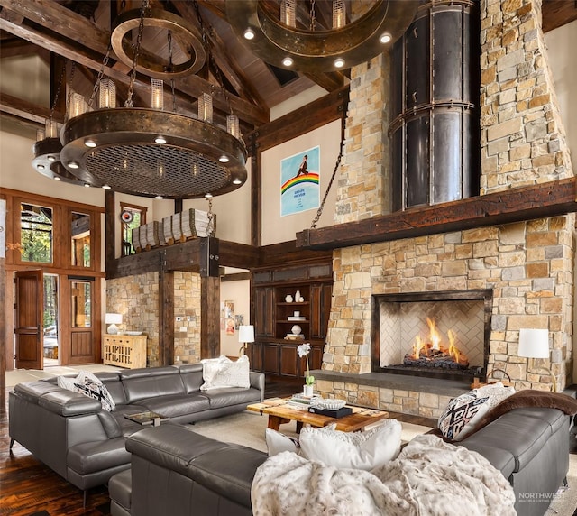 living room with beamed ceiling, a stone fireplace, high vaulted ceiling, and wood finished floors
