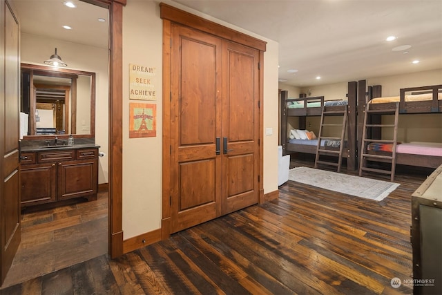 interior space with recessed lighting, dark wood-style floors, baseboards, and a sink