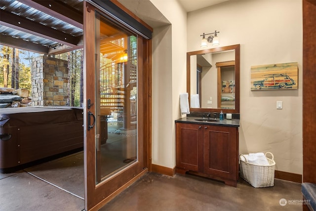 bathroom featuring concrete floors, vanity, baseboards, and beam ceiling