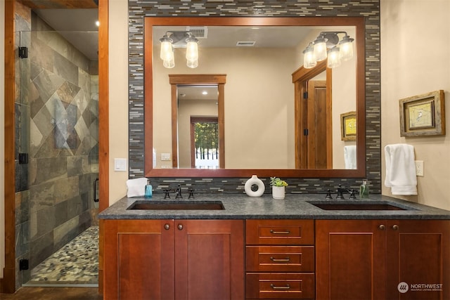 full bath with a sink, a stall shower, and decorative backsplash