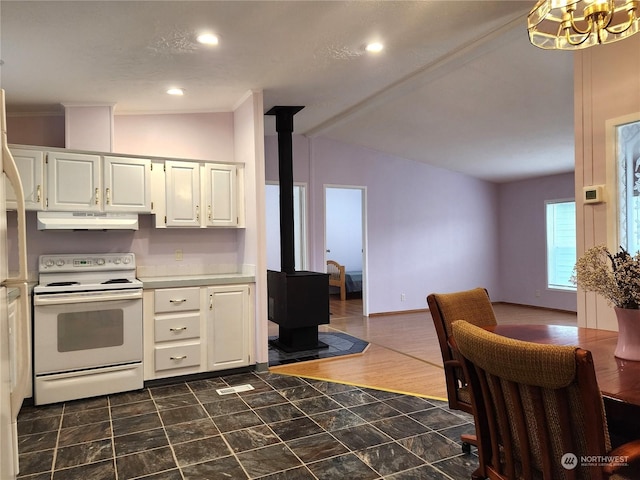 kitchen featuring electric stove, lofted ceiling, white cabinetry, a wood stove, and crown molding