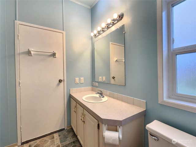 bathroom featuring a wealth of natural light, toilet, and vanity