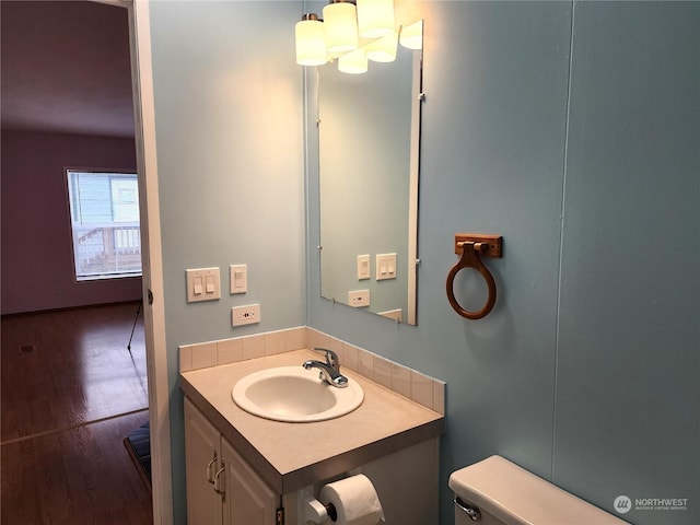 bathroom featuring toilet, hardwood / wood-style floors, and vanity