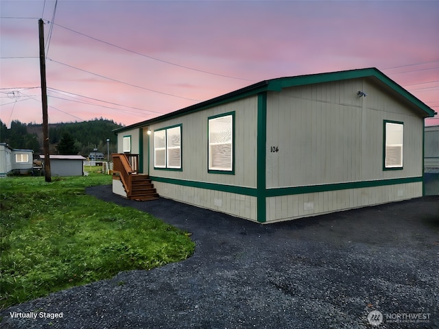 property exterior at dusk with a yard